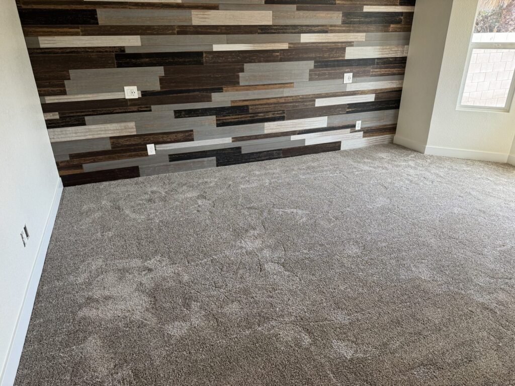 Multi-tone wood plank accent wall above new carpet