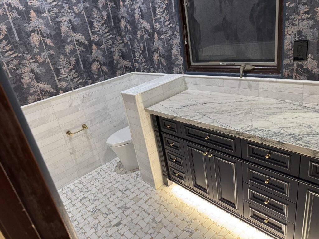 Bathroom Vanity with basketweave marble floor and under-cabinet lighting