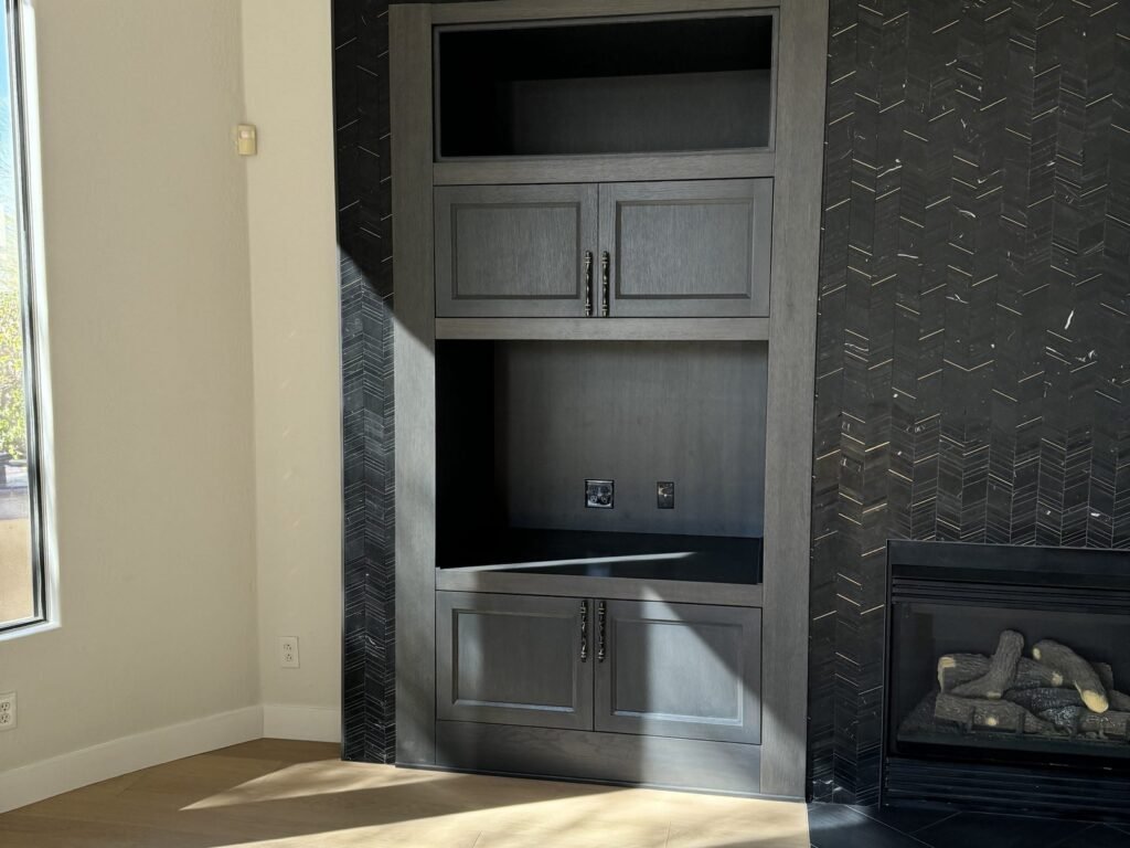 Built-in cabinetry beside a tiled fireplace surround