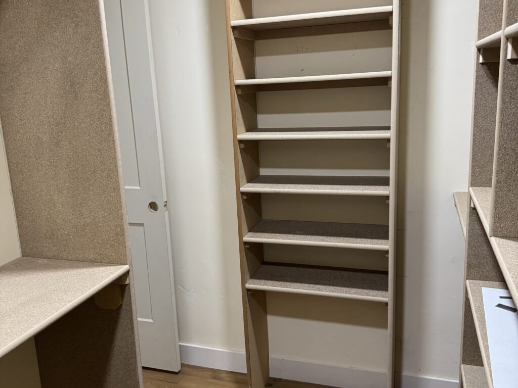 White closet shelving unit installed in a walk-in closet