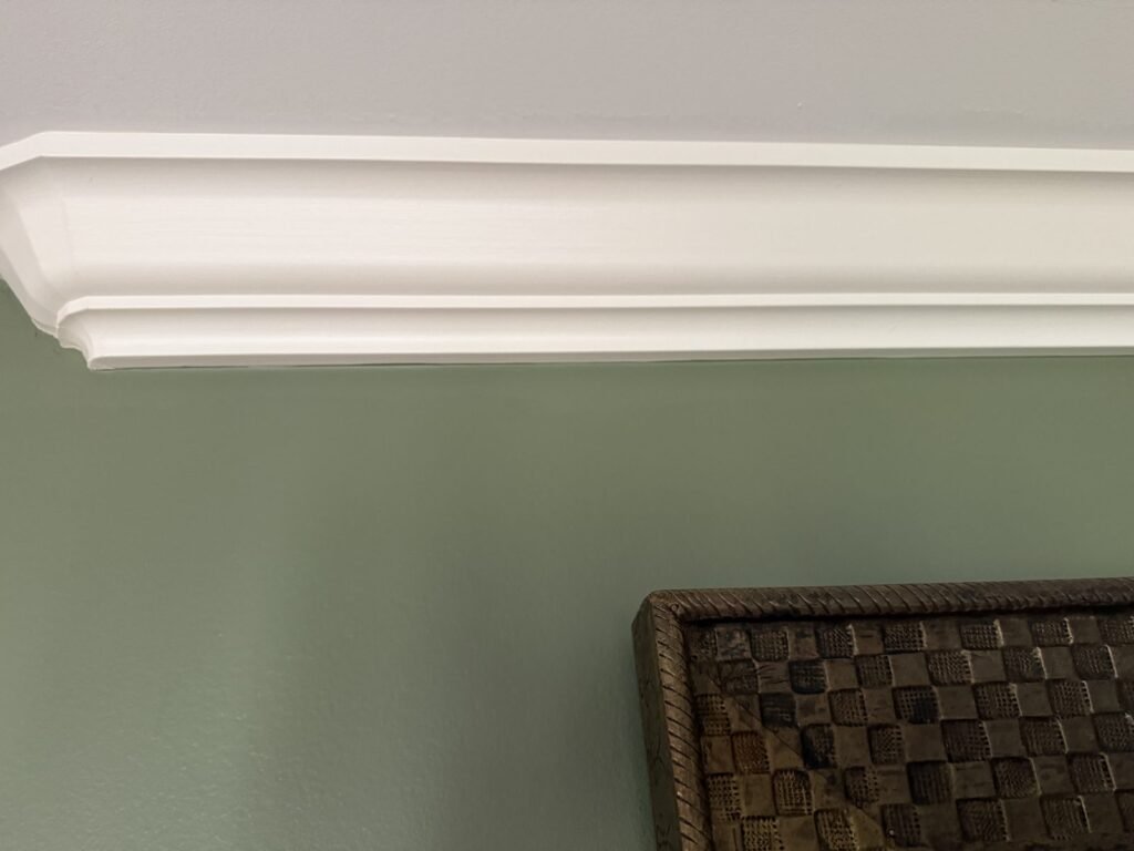 Crown molding against a freshly painted green wall