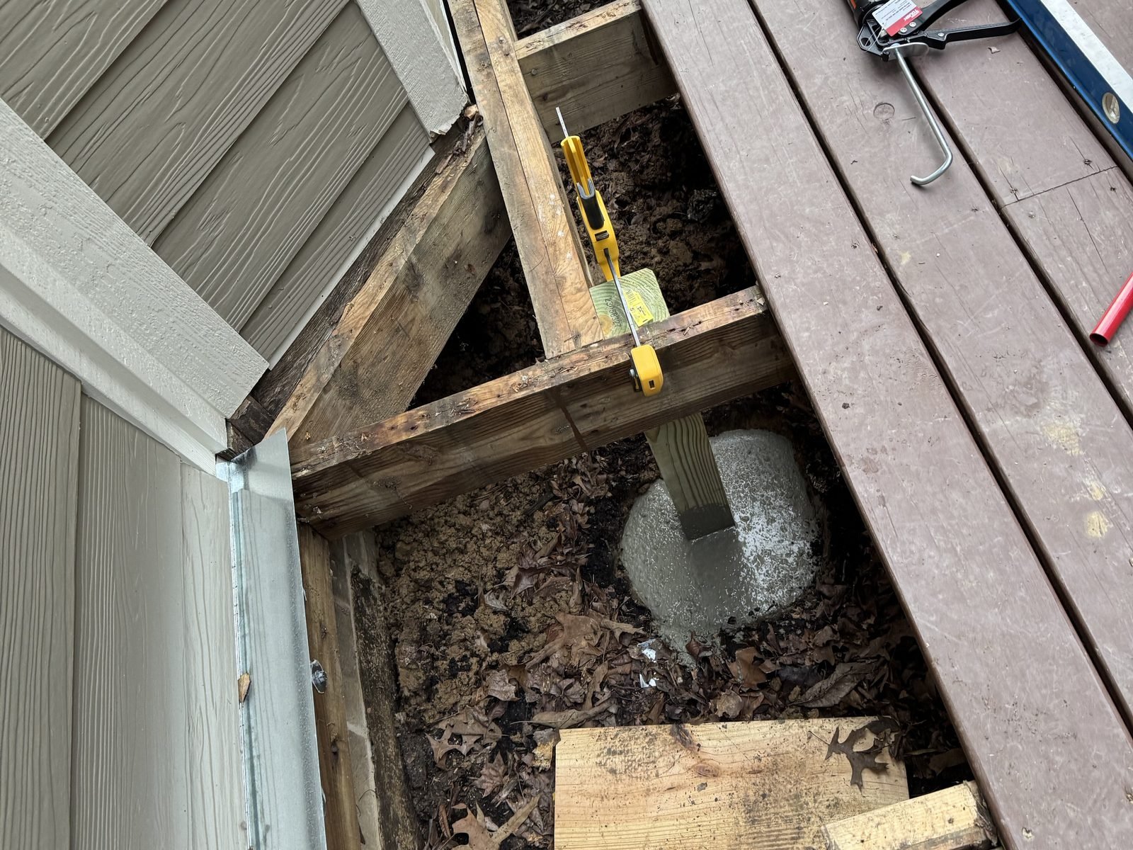 New pressure-treated deck framing on a concrete pier footing