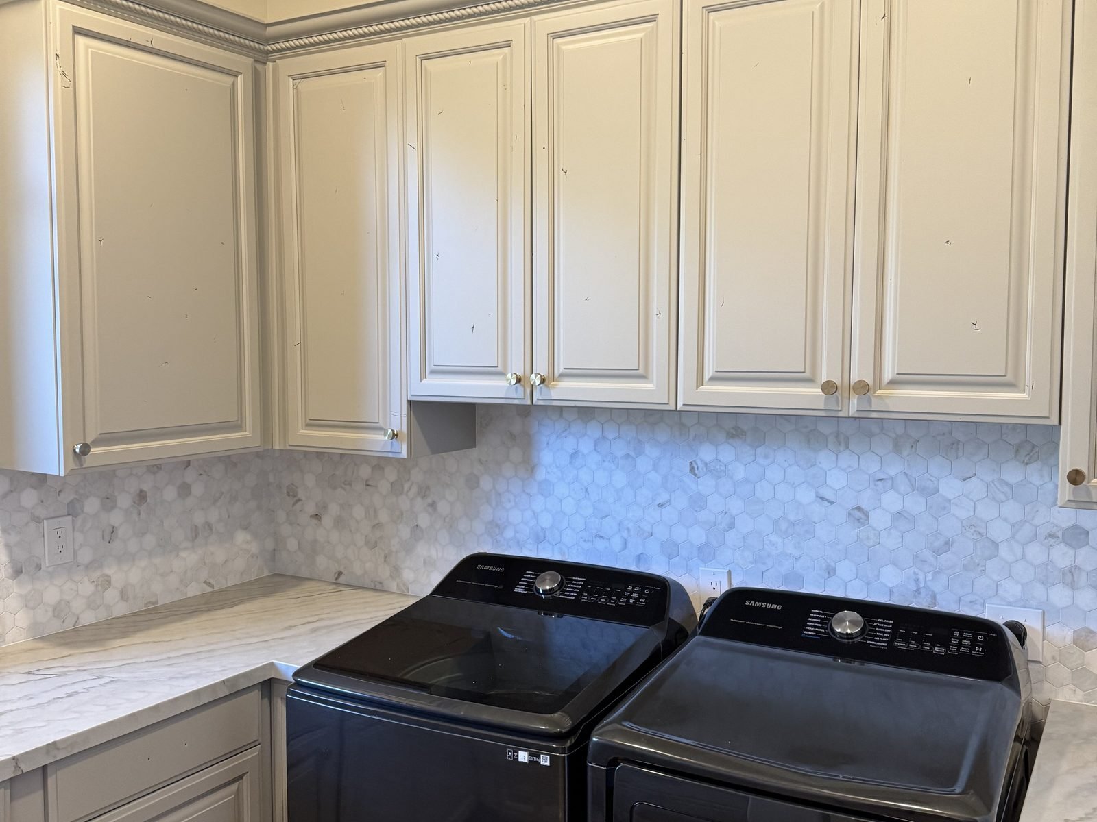 The same upper cabinets repainted off-white with new brass knobs