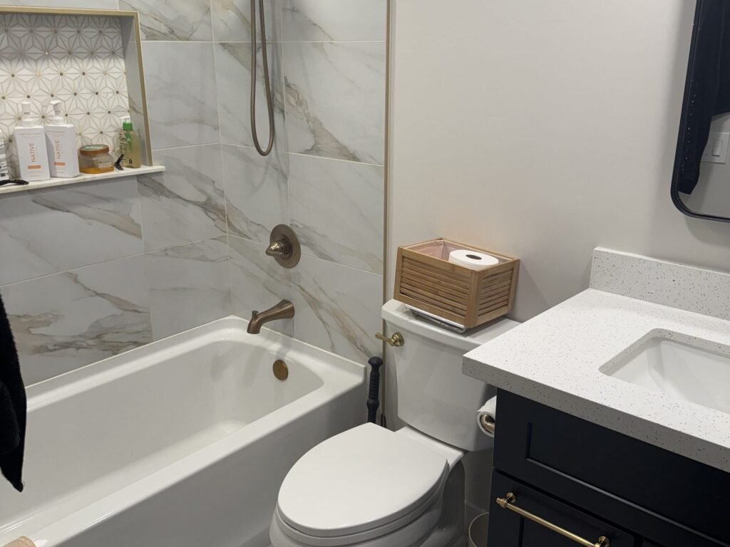 Bathroom with marble-look tub surround and dark vanity