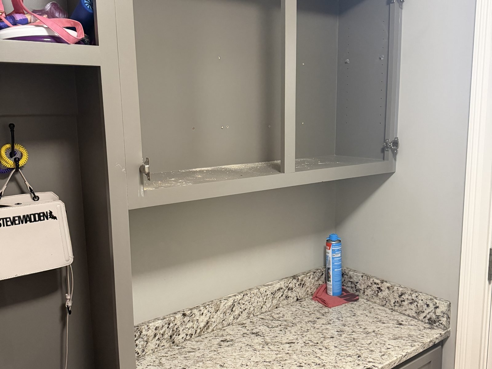 New upper cabinet installed above the mudroom counter, doors not yet hung