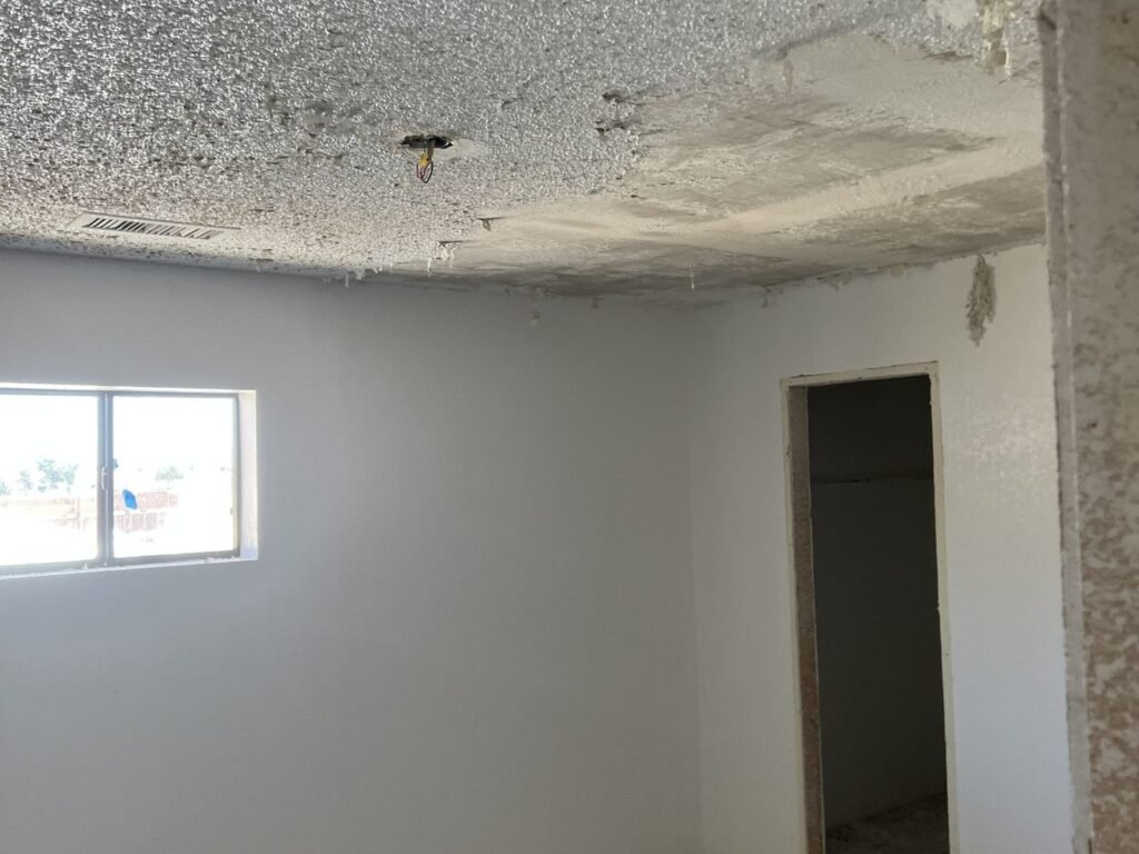 Ceiling with popcorn texture scraped back to bare board